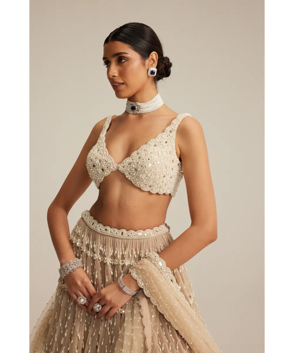 VVANI VATS- Light Beige Pearl Drop Multi Tier Lehenga Set.